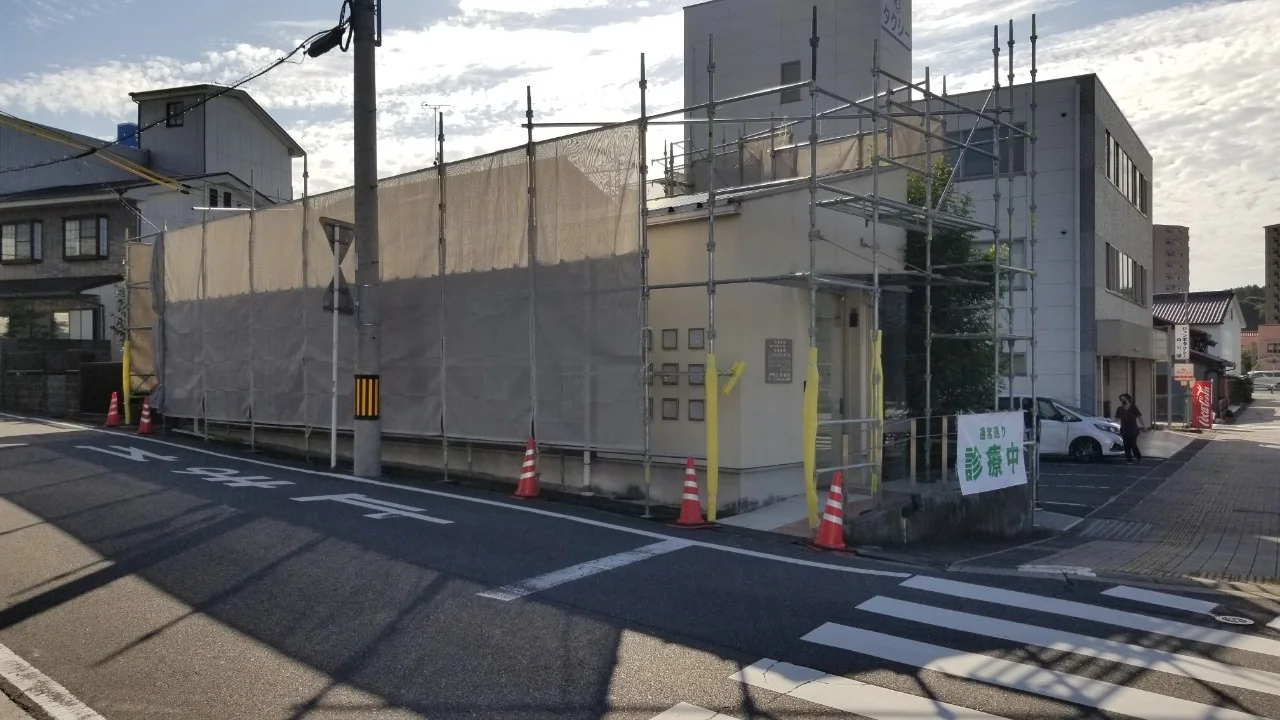 むぎ歯科の建物全体へ足場と飛散防止メッシュを設けた状態