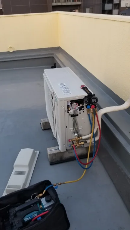 室外機側へ機器を接続し、冷媒を充填している様子