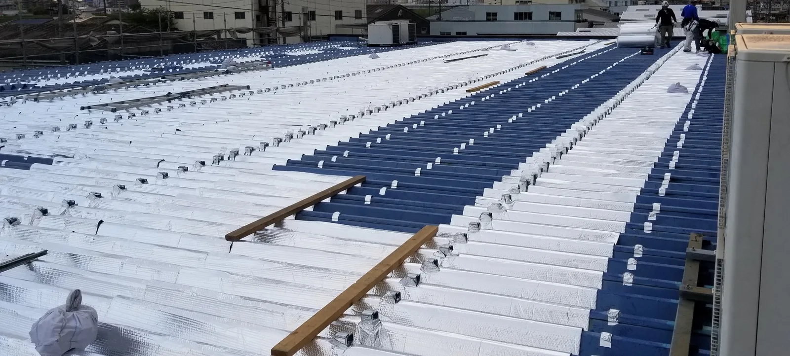 既存屋根の上へ遮熱シートを順に敷き込む