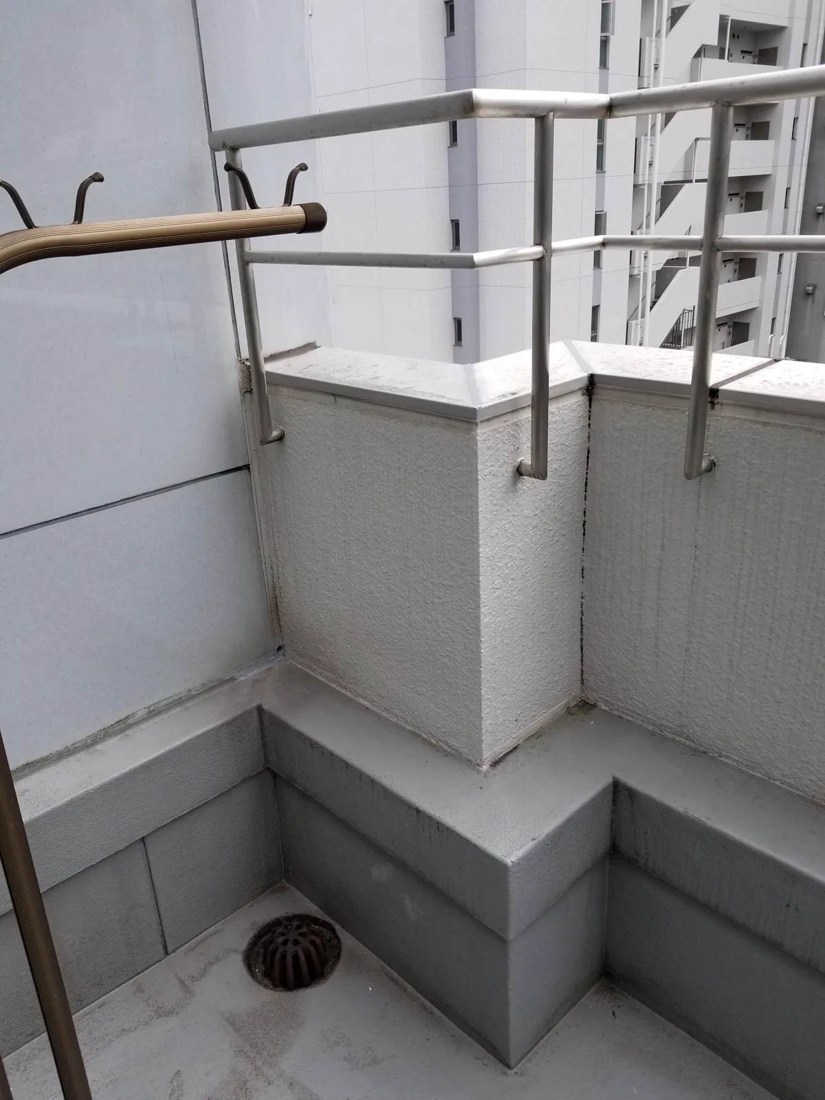 高層マンションの外部床にある柱下端と水抜きパイプの位置関係